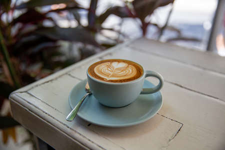 Blue cup of coffee on white rustic background with beautiful latte artの写真素材