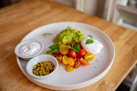 A set of products of the low carb keto diet. flax seeds, poached egg, smashed avocado, cherry...