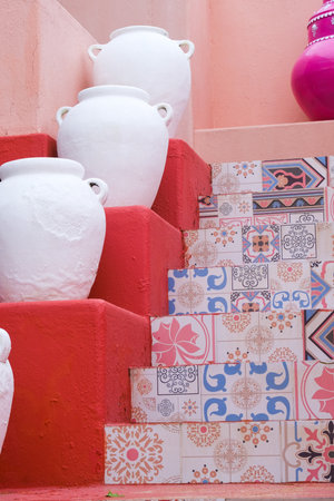 White pots on a staircase with vibrant patterned tiles against a pink wall.の写真素材