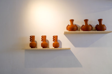 Terracotta Pottery Decor on Shelves Against a White Wallの写真素材