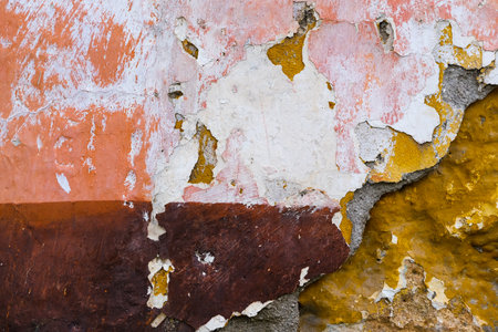 Textured Layers of Peeling Paint on a Weathered Wallの写真素材