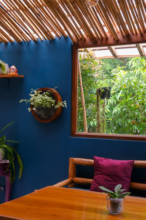 Cozy Interior Corner with Wooden Furniture and Lush Window Viewの写真素材