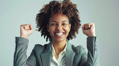 Successful Young Businesswoman Celebrating Achievement with a Winning Gesture. Minority.の素材