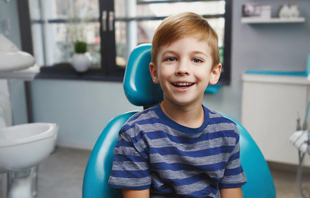 Portrait of a smiling little boy sitting in a dental chair.の素材