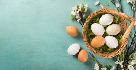 Happy easter. Easter eggs in basket and spring flowers on turquoise backgroundの素材