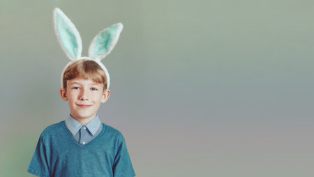 Cute boy with bunny ears on grey background. Space for textの素材