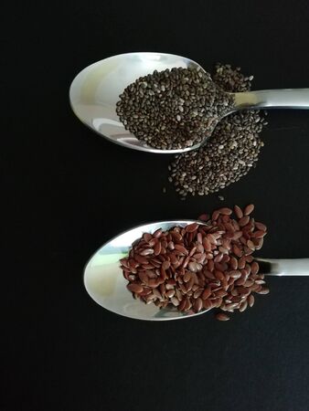 Chia and flax seeds in the a spoon on a black background.Copy spaceの写真素材
