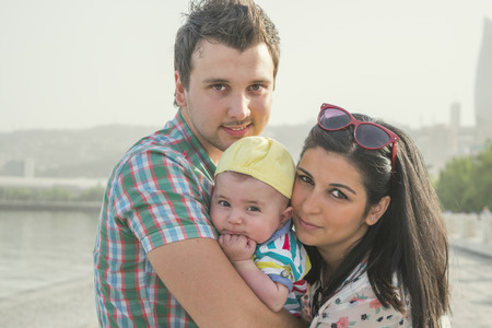 a young couple with a small child in the Park