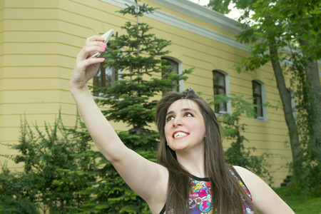 girl taking pictures of himself on the phone in the Parkの写真素材