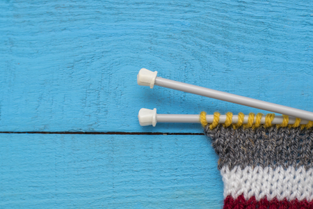 striped knitting on a blue wooden surface