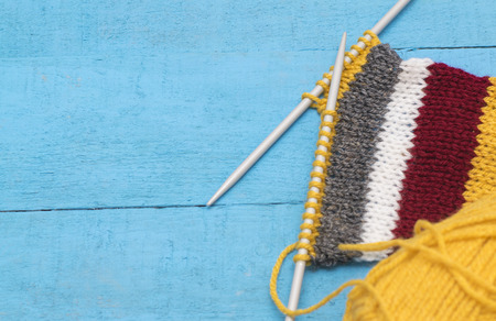 striped knitting on a blue wooden surface