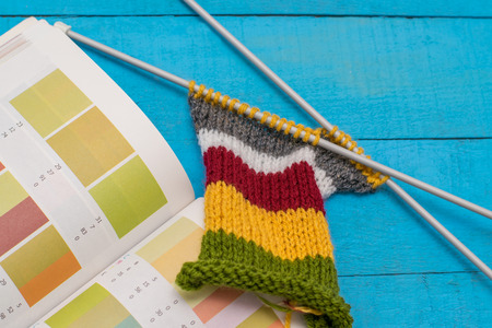 knitting and a book with shades on wooden table