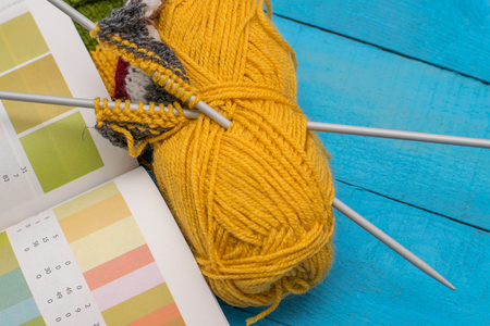 knitting and a book with shades on wooden tableの写真素材
