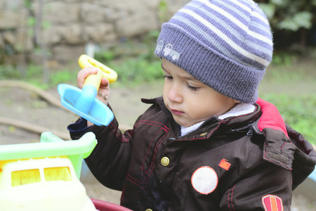 boy 2 years old playing with a machine outdoors