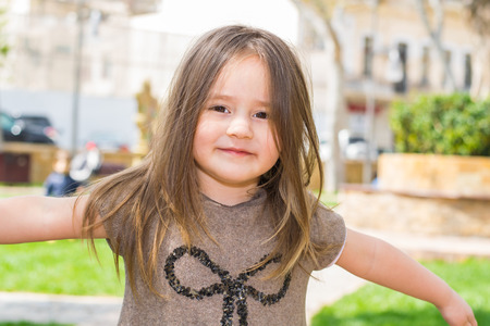 child girl of 3 years with long hair posing outdoorsの写真素材