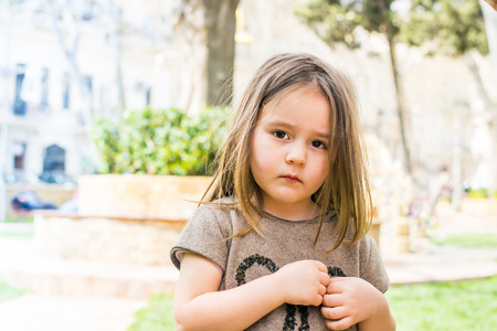 sad girl with long hair stands in summer Parkの写真素材