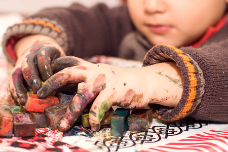 boy draws with hands soiled in a paintの写真素材