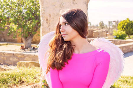 Brunette teenager girl with angel wings outdoorの写真素材
