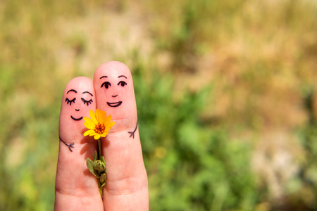 Drawn on the fingers of men with a flower. The concept of Dating. Family. Relationshipの写真素材
