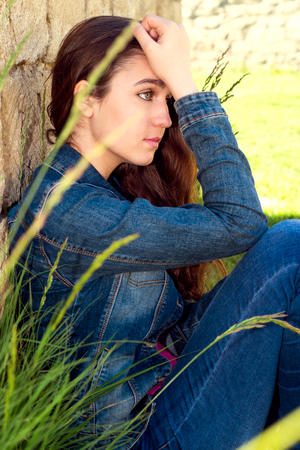 young woman in depression near the stone wallの写真素材