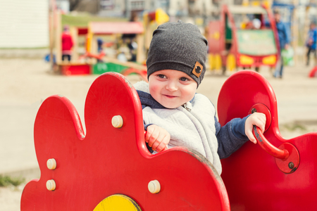 gay boy rides on a swing outdoorsの写真素材