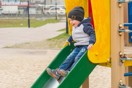 boy riding on a children's slideの写真素材