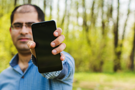 man with an outstretched hand with the phoneの写真素材