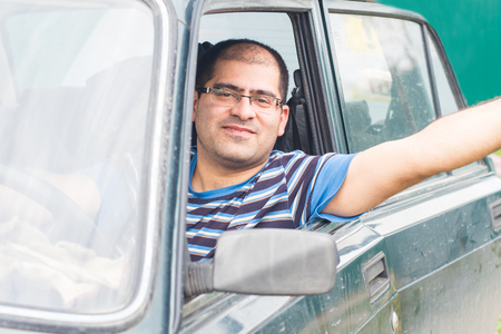 male driver sitting in the car and smilingの写真素材