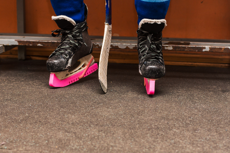 legs of a hockey player sitting on the benchの写真素材