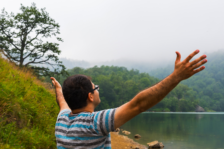 man on the lake with his hands upの写真素材