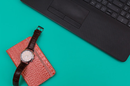 on the desktop laptop and notebook with a wrist watchの写真素材
