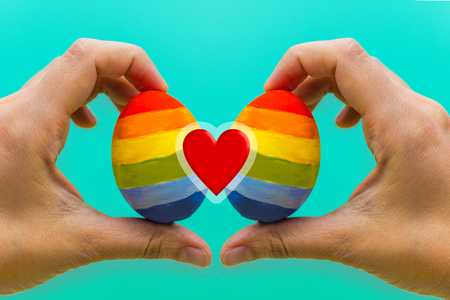 LGBT concept. two colored eggs in the handsの写真素材