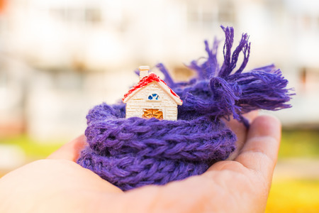 figure of the house wrapped in a scarf on hand. Concept.