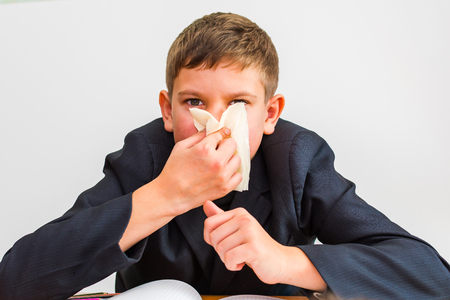 cold boy wipes his nose with a napkinの写真素材