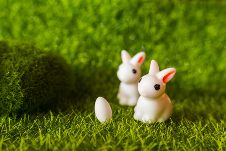 two figures of a rabbit and an egg on the grass. happy Easter conceptの写真素材