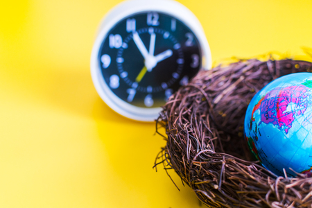 globe in the nest with clock. concept.の写真素材