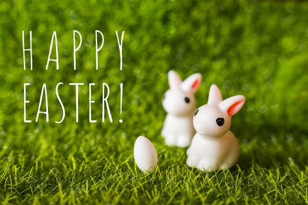 two figures of a rabbit and an egg on the grass. happy Easter conceptの写真素材