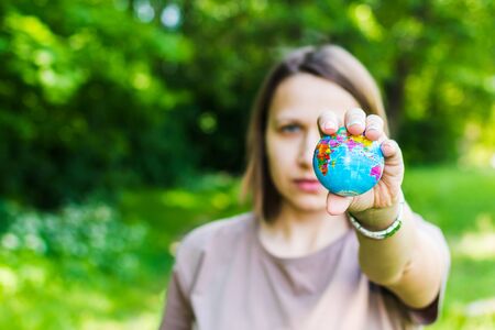 young woman holding small globeの写真素材