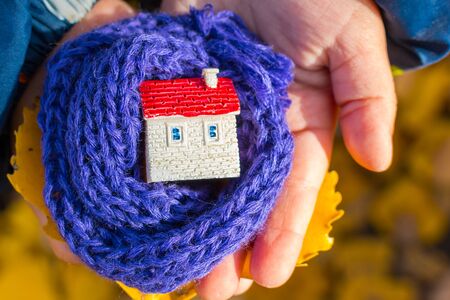 figure of the house wrapped in a scarf on hand. Concept.