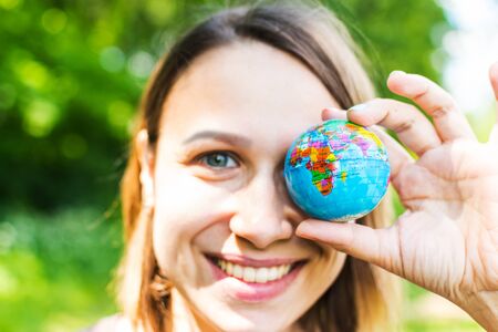 young woman holding small globe