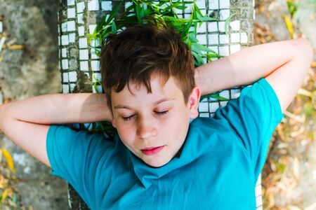 teen boy sleeping outdoors in summer