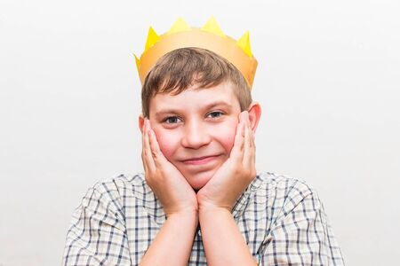 teen boy with crown on head on white backgroundの写真素材
