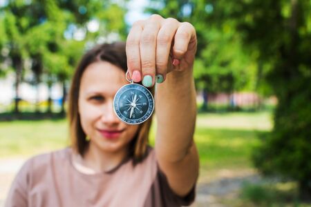 woman shows compass on nature backgroundの写真素材