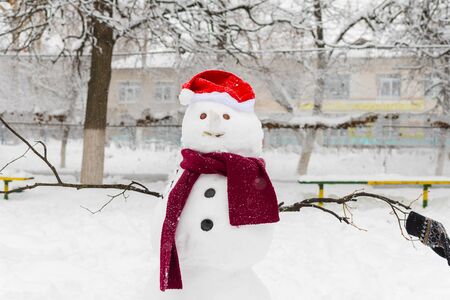 snowman in Santa hat and scarf outdoorsの写真素材