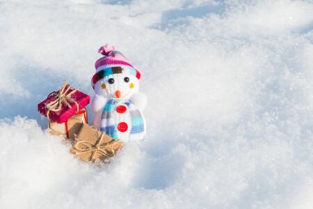 funny toy snowman with gifts in a snowdrift with a copy of spaceの写真素材