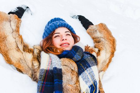 charming young woman lying in the snow.の写真素材