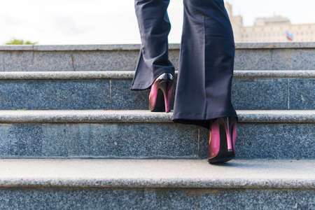 business woman climbs the stairs. Feet on the stepsの写真素材