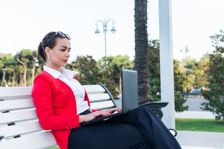 young beautiful woman working on laptop in park.の写真素材
