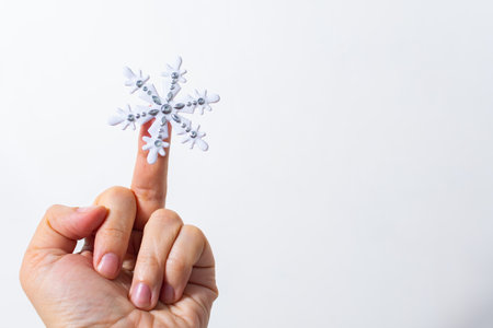 Finger gesture with snowflake on white backgroundの写真素材