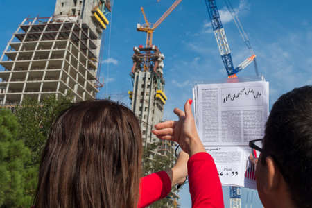 two people are discussing a house under construction
